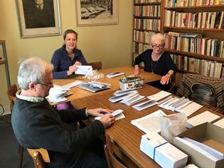 A group of people sitting at a table in a library

Description automatically generated