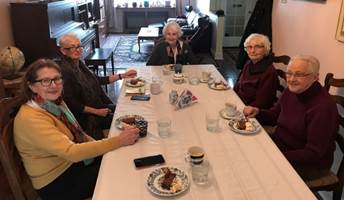 A group of people sitting at a table in a restaurant

Description automatically generated