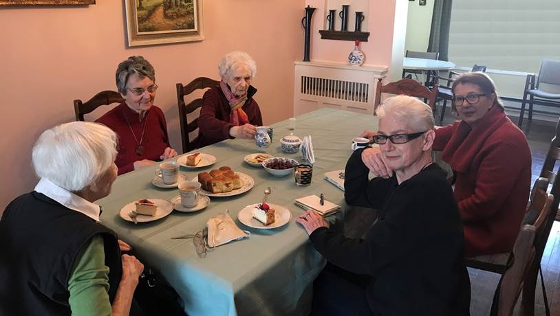 A group of people sitting at a table eating food
Description automatically generated