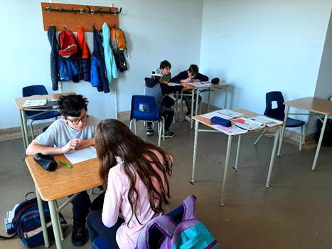 A group of people sitting at desks in a classroom
Description automatically generated with low confidence