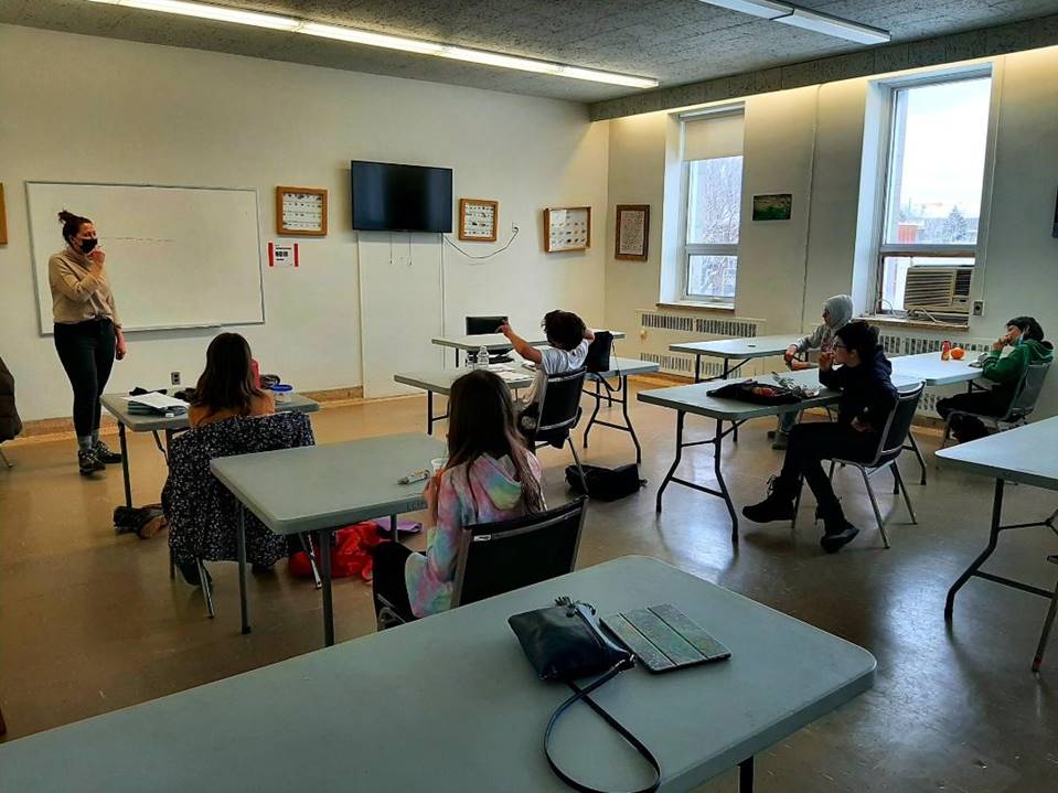 A group of people sitting at desks in a room

Description automatically generated with medium confidence