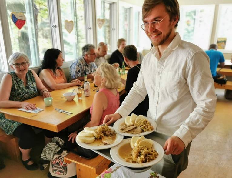 A person holding a tray of food
Description automatically generated