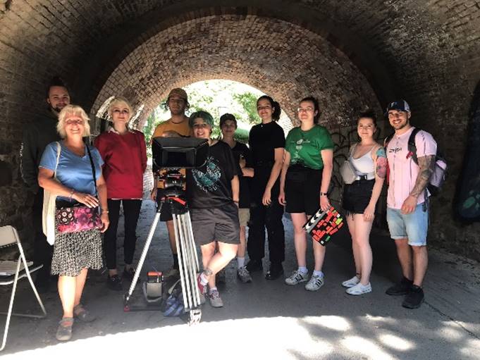 A group of people standing under a tunnel

Description automatically generated