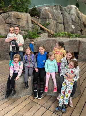 A group of children sitting on a rock

Description automatically generated