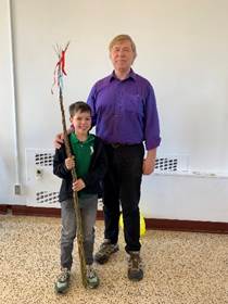 A person and child holding a stick

Description automatically generated