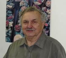 A person smiling in front of a poster

Description automatically generated