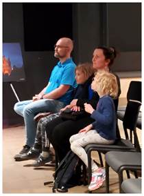 A group of people sitting in chairs

Description automatically generated