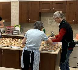 A couple of women in a kitchen

Description automatically generated