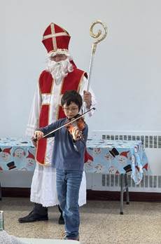 A child playing a violin with a saint nicholas garment

Description automatically generated