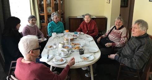 A group of people around a table

Description automatically generated