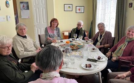 A group of people sitting around a table

AI-generated content may be incorrect.