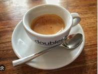A cup of coffee on a saucer with a spoon
Description automatically generated