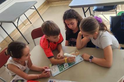 A group of kids sitting at a table

AI-generated content may be incorrect.