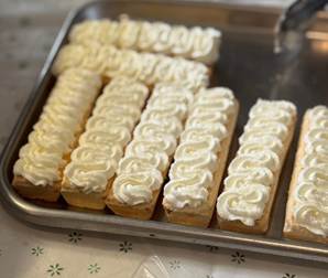 A tray of cakes with white frosting

AI-generated content may be incorrect.